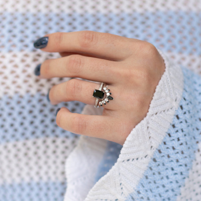 Black Onyx Stacking Ring in Sterling Silver by Aquamarise, featuring a curved design with a rectangular black onyx stone on a hand wearing a textured knit blue and white sweater.