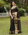 Black Maheshwari silk saree with small gold buti across a semi-sheer body and a wide decorative gold border, handwoven in Maheshwar
