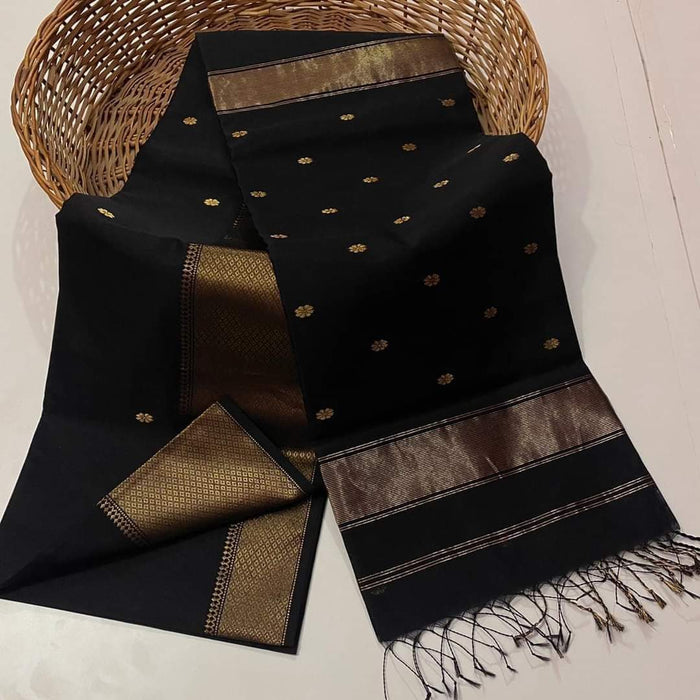 Black Maheshwari silk saree with small gold buti across a semi-sheer body and a wide decorative gold border, handwoven in Maheshwar