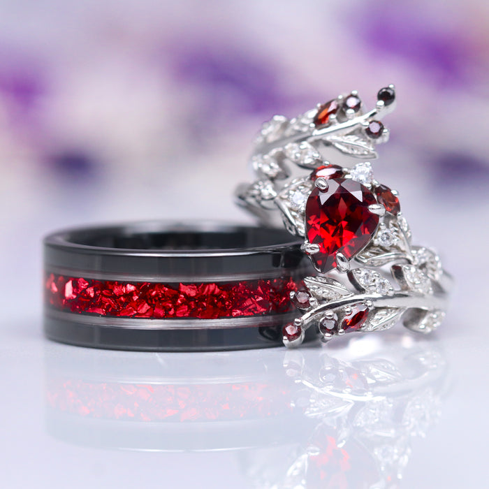 Wisteria Natural Red Garnet Leaf Couples Ring Set by Aquamarise, featuring a sterling silver ring with a heart-shaped red garnet surrounded by leaf motifs and a black band inlaid with crushed red garnets, part of Matching Couples' Rings and January Birthstone Jewelry collections.