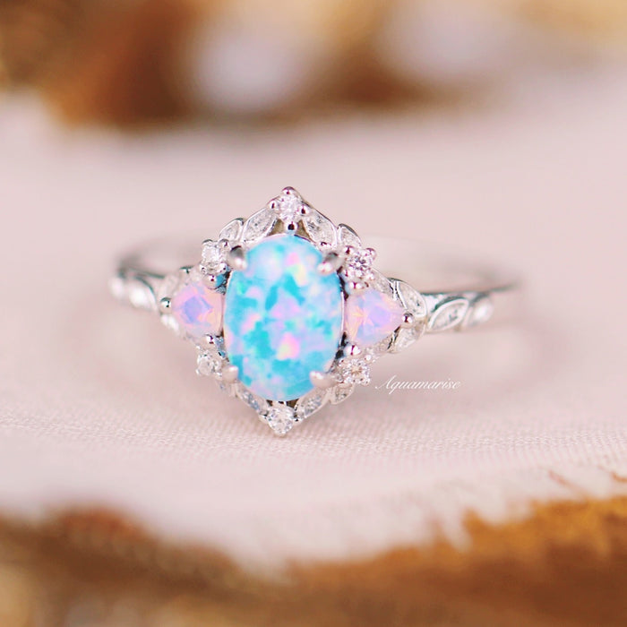 Blue Fire Opal & Opalescent Sapphire Leaf Engagement Ring in Sterling Silver by Aquamarise featuring a vibrant opal center stone flanked by opalescent sapphires and intricate leaf details on the band.