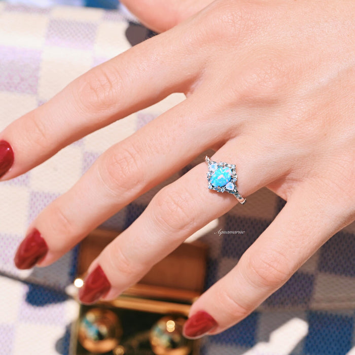 Blue Fire Opal & Opalescent Sapphire Leaf Engagement Ring in Sterling Silver by Aquamarise featuring a radiant blue fire opal surrounded by opalescent sapphires and delicate leaf motifs.
