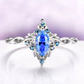 Blue Moissanite Butterfly Marquise Engagement Ring in 14K White Gold by Aquamarise Gold, featuring a nature-inspired band with intricate details and vibrant blue gemstones for a unique engagement ring.