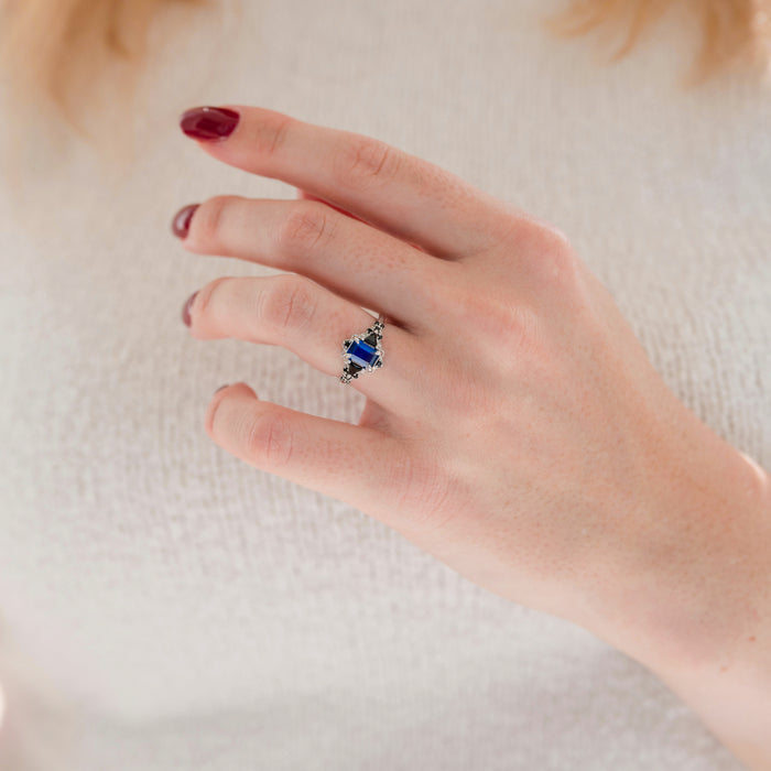 Blue Sapphire & Black Onyx Leaf Engagement Ring- 14K White Gold elegantly worn on hand, featuring a striking blue sapphire and black onyx design by Aquamarise Gold.