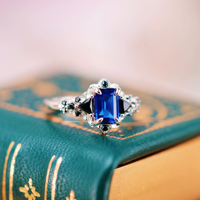 Blue Sapphire & Fire Opal Couples Ring Set featuring a deep blue sapphire center and black onyx accents in an intricate silver setting by Aquamarise, symbolic of love and commitment.