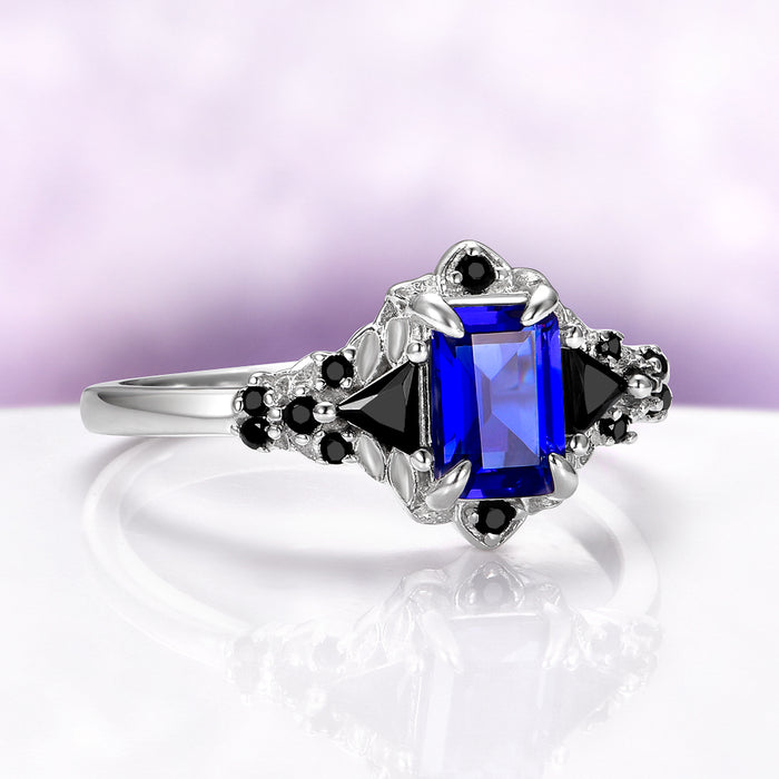 Blue Sapphire & Black Onyx Leaf Engagement Ring- 14K White Gold by Aquamarise Gold featuring a deep blue sapphire center with black onyx accents in a nature-inspired setting.