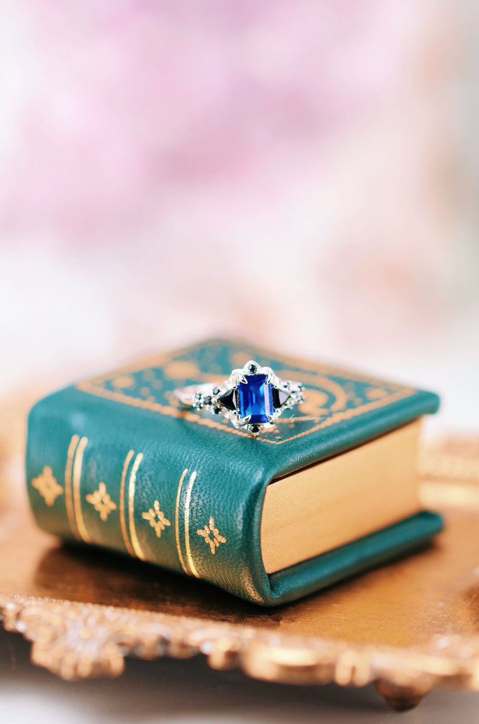 Blue Sapphire & Black Onyx Leaf Engagement Ring- 14K White Gold featuring a deep blue sapphire center flanked by black onyx accents, set in a white gold band by Aquamarise Gold.