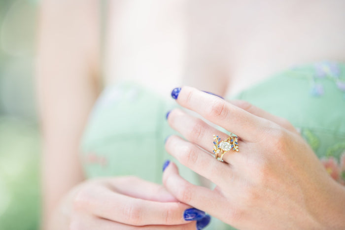 Lab-Grown Diamond & Sapphire Leaf Engagement Ring Set in 14K Solid Yellow Gold (IGI Certified) worn on hand, showcasing intricate leaf design with blue sapphires by Aquamarise Gold.