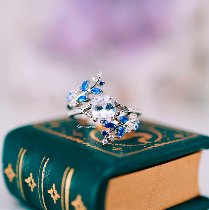 Blue Sapphire & Simulated Diamond Leaf Engagement Ring Set in Sterling Silver by Aquamarise featuring intricate leaf designs with vibrant blue sapphires and sparkling simulated diamonds.
