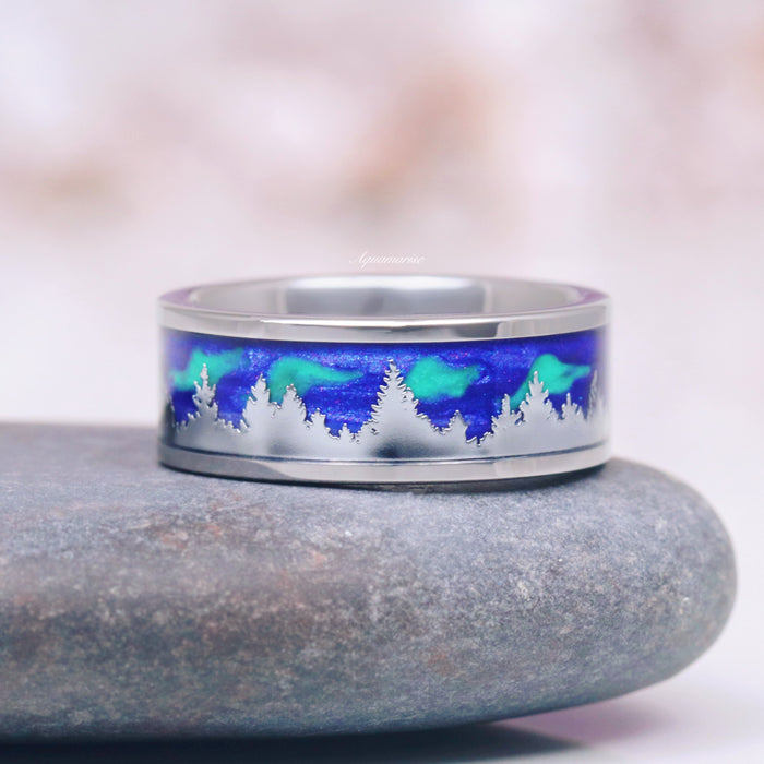 Borealis & Tanzanite Couples Ring Set- Northern Lights & Trees featuring a polished band with a vivid blue and green aurora borealis inlay above an engraved silhouette of pine trees by Aquamarise, part of Matching Couples' Rings and Nature-Inspired collections.