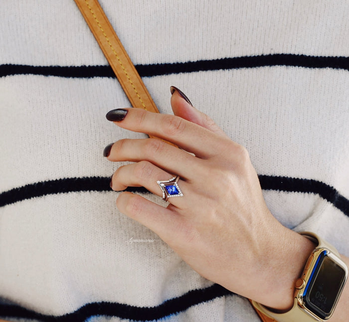 Borealis & Tanzanite Couples Ring Set- Northern Lights & Trees displayed on a hand wearing a striped sweater and a smartwatch strap, featuring a kite-shaped tanzanite surrounded by diamonds on a white gold band, crafted by Aquamarise.