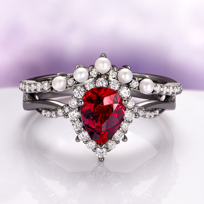 Briar Natural Red Garnet & Pearl Ring Set in Black Ruthenium featuring a pear-shaped red garnet surrounded by diamonds and pearls on a twisted black ruthenium band by Aquamarise.