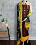 Unstitched brown Katan silk suit set block printed with tight rows of small diamonds in teal, blue and white, a wide solid yellow band across the bottom edge and a dupatta bordered with large abstract organic shapes.
