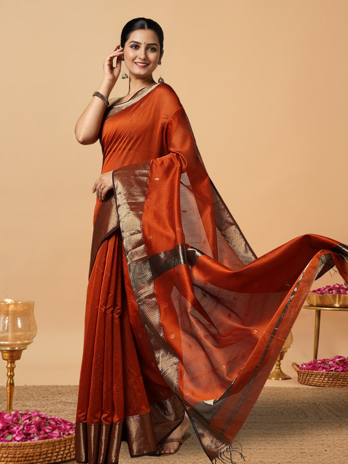 Handloom Maheshwari silk saree in burnt orange, flower buti scattered across the body, with a wide golden zari border