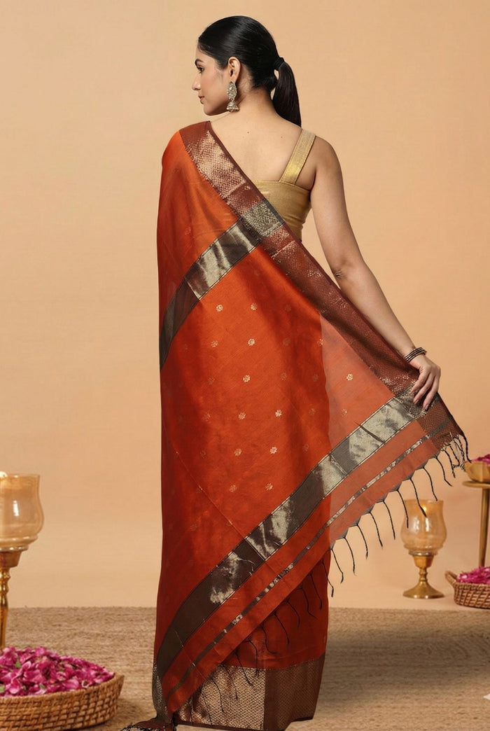 Handloom Maheshwari silk saree in burnt orange, flower buti scattered across the body, with a wide golden zari border