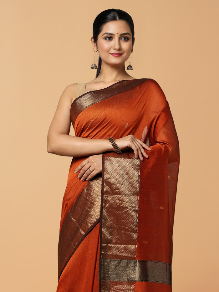 Handloom Maheshwari silk saree in burnt orange, flower buti scattered across the body, with a wide golden zari border