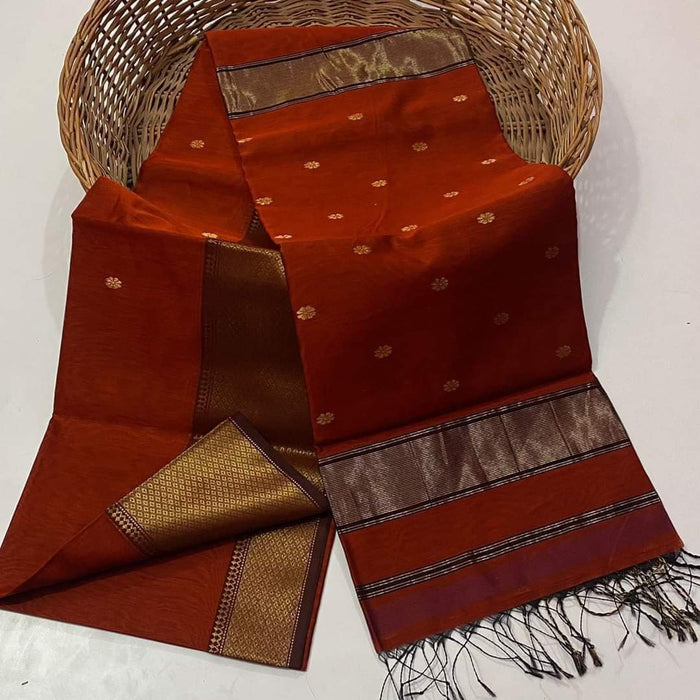Handloom Maheshwari silk saree in burnt orange, flower buti scattered across the body, with a wide golden zari border