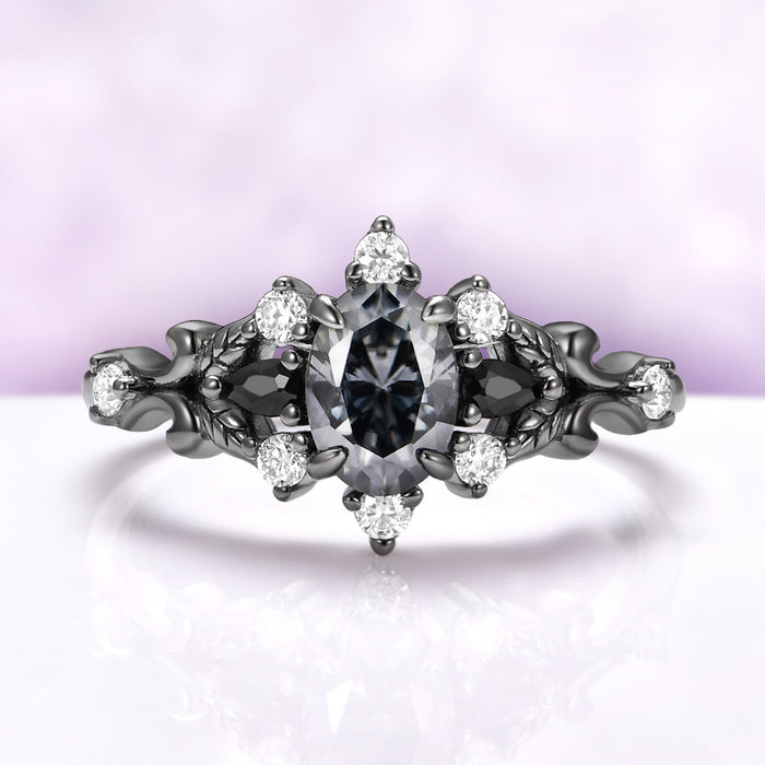 Carmilla engagement ring in black ruthenium, oval gray moissanite between black onyx pears with carved leaf and vine shoulders