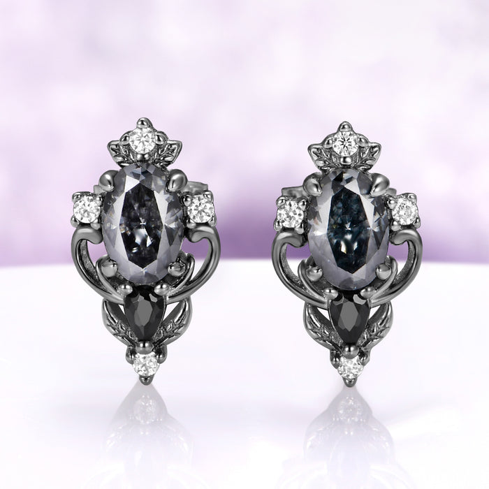 Carmilla gray moissanite stud earrings in black ruthenium, oval centers with black onyx pears and carved leaf and scroll frames