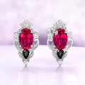 Carmilla lab-grown ruby stud earrings in sterling silver, oval centers with black onyx pears and carved leaf and scroll frames