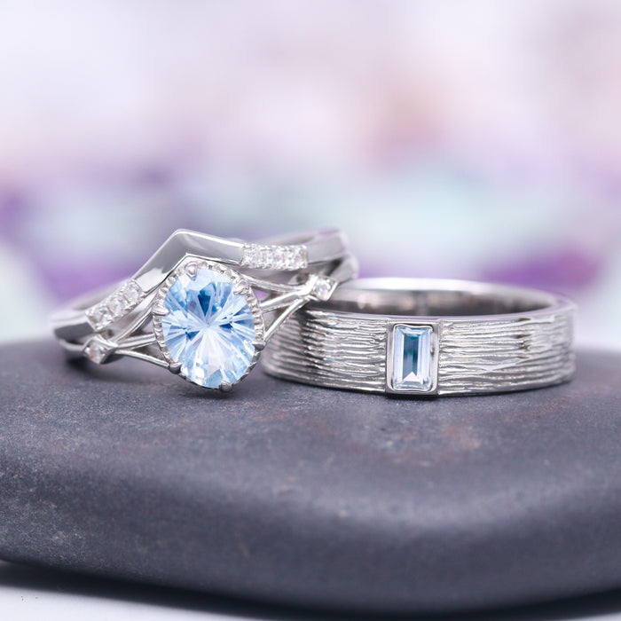 Celtic Aquamarine Couples Ring Set by Aquamarise featuring an oval aquamarine center stone with diamond accents on an intricately designed silver band paired with a textured silver ring with a rectangular aquamarine, part of Matching Couples' Rings and March Birthstone Jewelry collections.