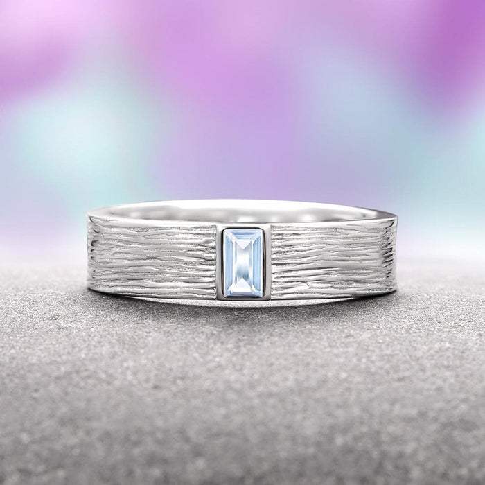 Celtic Aquamarine Couples Ring Set by Aquamarise features a textured sterling silver band with a rectangular aquamarine gemstone centerpiece, blending artisan craftsmanship with timeless symbolism, part of Matching Couples' Rings and March Birthstone Jewelry collections.