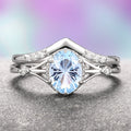 Fireworks Cut Aquamarine Couples Ring Set by Aquamarise featuring a sparkling oval aquamarine center stone with intricate silver band accents and small diamond details, part of Matching Couples' Rings and March Birthstone Jewelry collections.