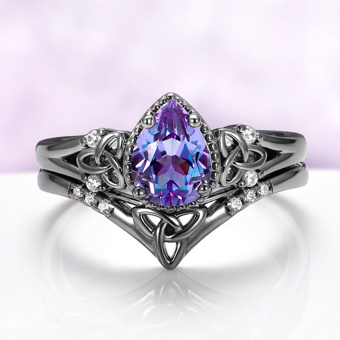Celtic Knot Alexandrite Ring Set in Black Ruthenium by Aquamarise, featuring a pear-shaped alexandrite with intricate knotwork and diamond accents on a black ruthenium band.