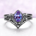 Celtic Knot Alexandrite Ring Set in Black Ruthenium by Aquamarise, featuring a pear-shaped alexandrite with intricate knotwork and diamond accents on a black ruthenium band.