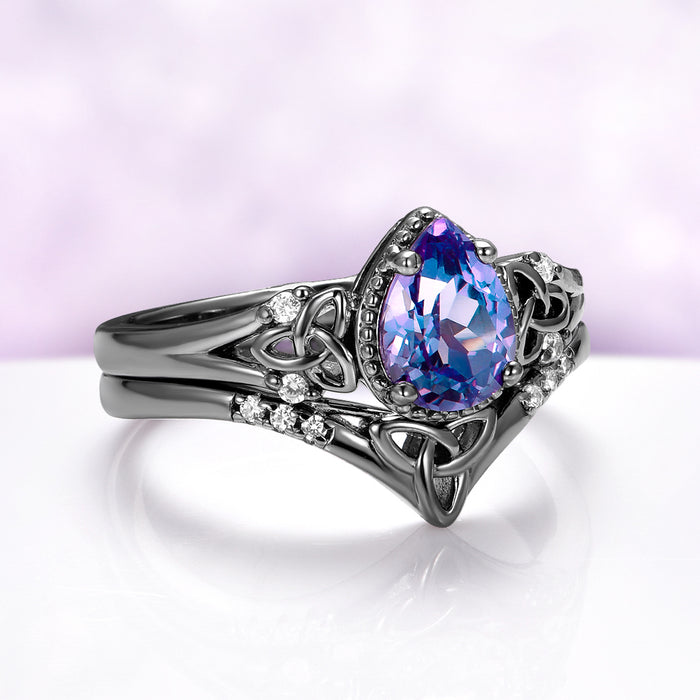 Celtic Knot Alexandrite Ring Set in Black Ruthenium by Aquamarise, featuring a pear-shaped alexandrite and intricate Celtic knotwork with diamond accents on a black ruthenium band.