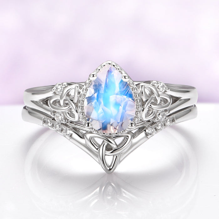 Celtic Knot Moonstone Engagement Ring Set in 14K White Gold by Aquamarise Gold, featuring a pear-shaped moonstone with intricate Celtic knotwork and sparkling gemstone accents.