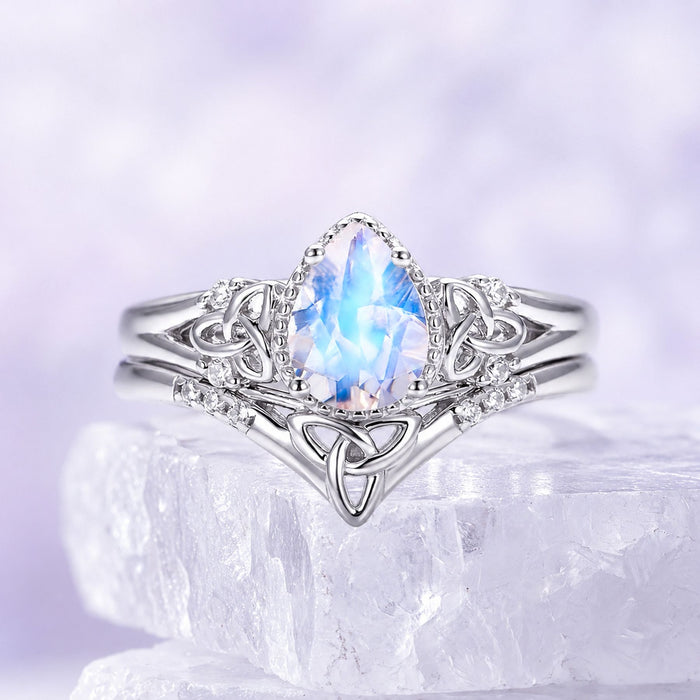 Sterling silver moonstone bridal set with marquise moonstone center and Celtic trinity knot band resting on a raw white crystal, Aquamarise collection banner