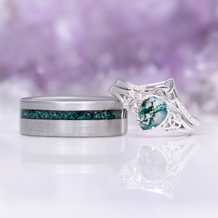 His and hers moss agate wedding rings side by side showing the tungsten inlay next to the pear cut Celtic knot ring