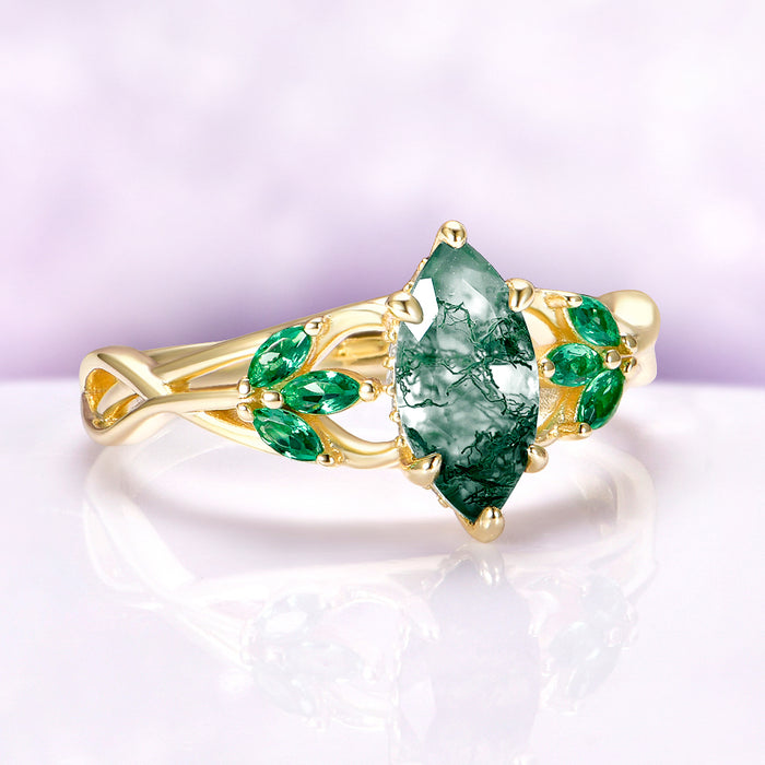 Moss Agate & Emerald Celtic Knot Ring in 14K Solid Yellow Gold by Aquamarise Gold, featuring a marquise moss agate center with emerald accents in a nature-inspired design.