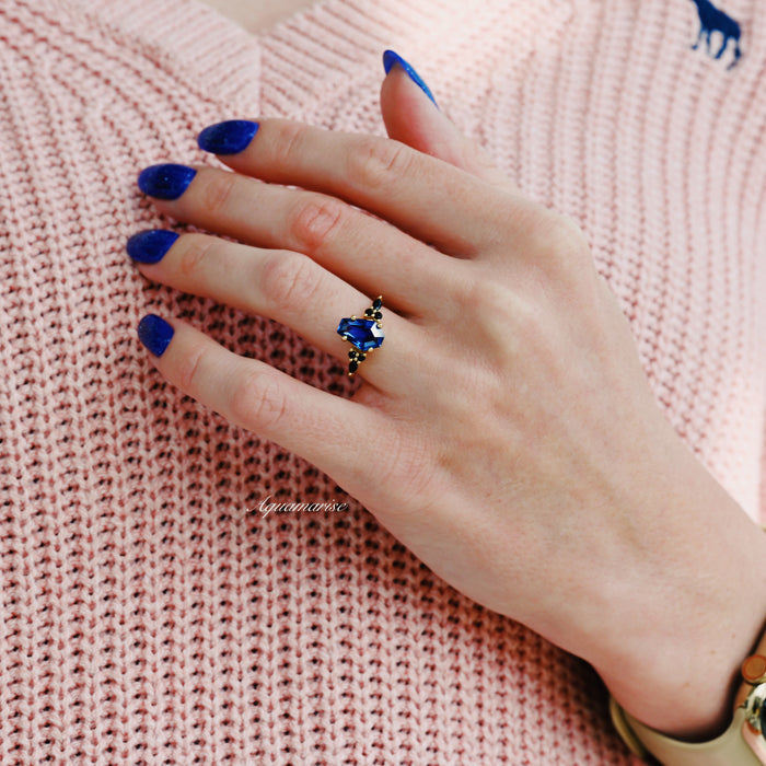 Coffin Cut Blue Sapphire and Gold Leaf Couples Ring Set featuring a deep blue sapphire and black gemstone accents in gold, styled with blue nail polish by Aquamarise.
