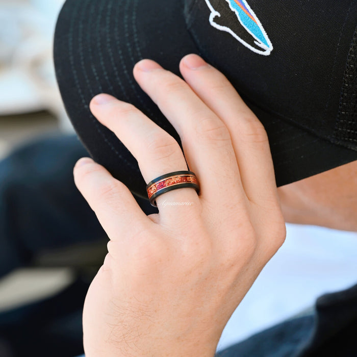 Black finish ring with ruby red inlay on a hand, styled with a black cap, showcasing the Skye Kite® Ruby & Rose Gold Leaf Couples Ring Set by Aquamarise.