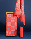 Coral red Katan silk suit set hand block printed with blue circular motifs and small white leaf sprigs with metallic gold detail, and a frayed fringe on the dupatta.