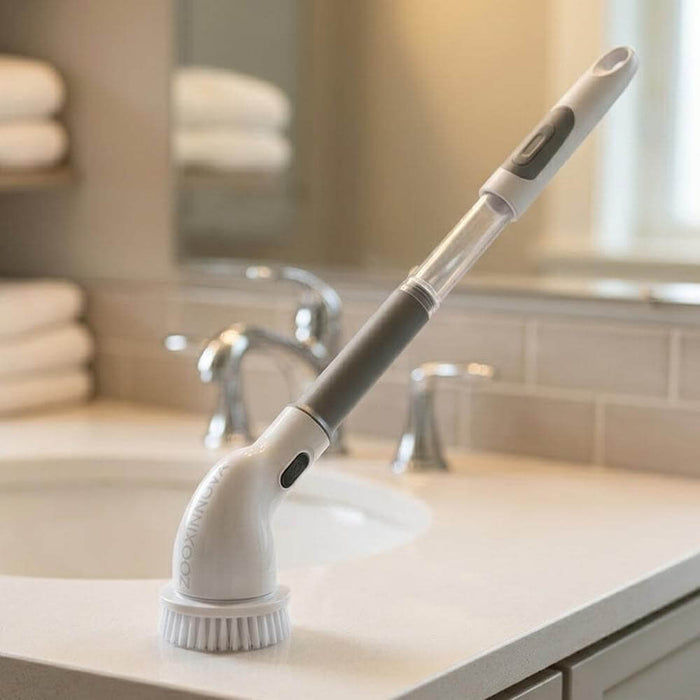 Cordless electric spin scrubber with extendable handle on a bathroom counter.