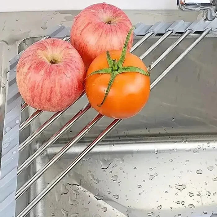 corner sink dish drying rack with apples and a tomato resting on a stainless steel surface in a kitchen sink