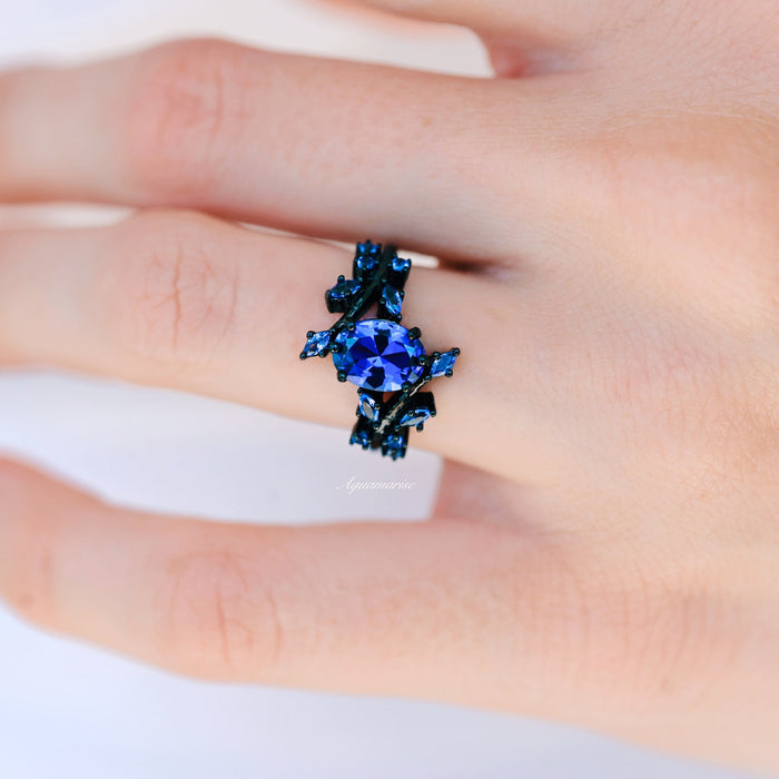 Cornflower Sapphire & Orion Nebula™ Couples Ring Set by Aquamarise, featuring a striking blue sapphire set in an intricate black band with celestial-inspired accents for matching couples rings.
