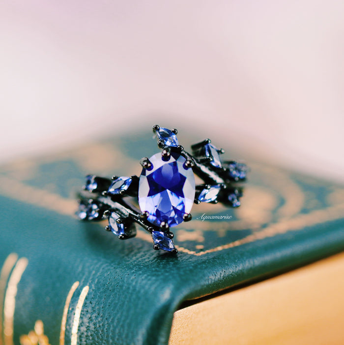 Cornflower Sapphire & Orion Nebula™ Couples Ring Set by Aquamarise, featuring an oval cornflower sapphire on a black band with branching galaxy-inspired accents for matching couple rings.