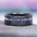 Lavender Fire Opal & Emerald Leaf Couples Ring Set by Aquamarise, featuring a black finish band with a hammered texture and a striking inlay of iridescent lavender fire opal and emerald hues, part of Matching Couples' Rings and Fantasy-Inspired Couples Rings collections.
