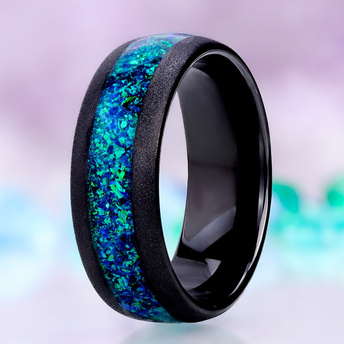 Crushed peacock opal men's wedding band in sandblasted black tungsten, 8mm dome with a wide lab-created blue-green opal channel