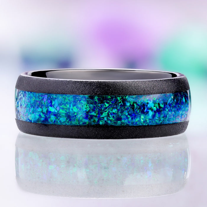 Front view of the sandblasted black tungsten band showing the wide peacock opal inlay between two matte black rails