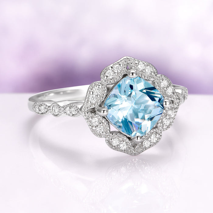 Cushion Cut Vintage Aquamarine Ring in Sterling Silver by Aquamarise, featuring a radiant cushion-cut aquamarine center set in an Art Deco-inspired halo with delicate diamond accents on an intricately detailed sterling silver band.