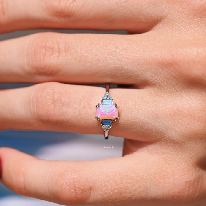 Dainty Pink Fire Opal Ring in Sterling Silver by Aquamarise, showcasing a luminous rectangular pink fire opal centerpiece accented with opalescent sapphires on a minimalist sterling silver band, part of Sterling Silver Rings and October Birthstone collections.