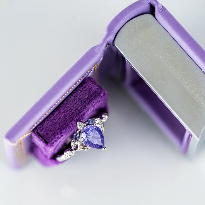 Dawn Court Leather Book Ring Box - Amethyst Light Edition (Small) by Aquamarise, purple leather book-style ring box with a fantasy-inspired silver ring featuring a heart-shaped amethyst gemstone.