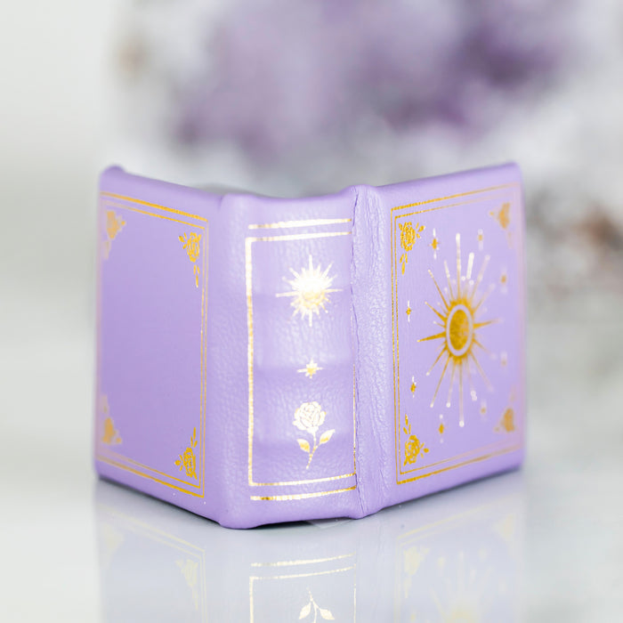 Dawn Court Leather Book Ring Box - Amethyst Light Edition (Small) by Aquamarise, a delicate lavender leather ring box with gold celestial and floral accents, perfect for meaningful jewelry gifts.