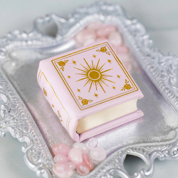 Dawn Court Leather Book Ring Box - Blushing Dawn Edition (Small) by Aquamarise on ornate silver tray surrounded by pink stones, ideal for meaningful jewelry gifts and keepsake proposals.