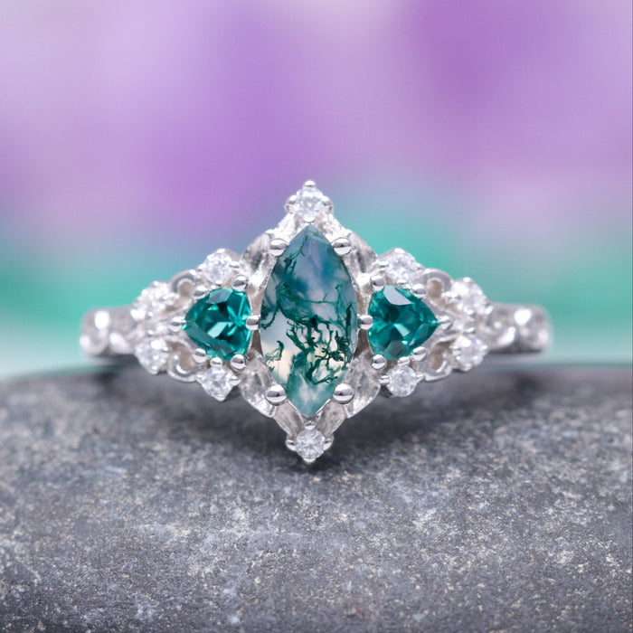 Elain Moss Agate & Teal Sapphire Leaf Ring- 14K White Gold by Aquamarise Gold, featuring a marquise moss agate centerpiece flanked by teal sapphire accents on a delicate white gold band, part of nature-inspired and non-traditional engagement ring collections.